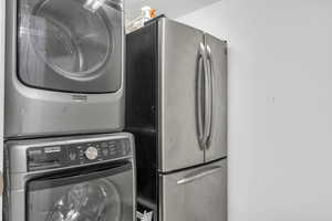 Laundry room with stacked washer and clothes dryer