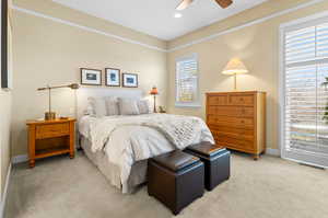 Carpeted bedroom featuring ceiling fan, access to outside, and multiple windows