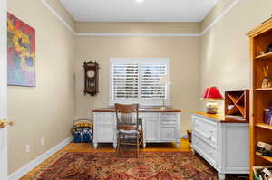 Office with built in desk and dark hardwood / wood-style floors