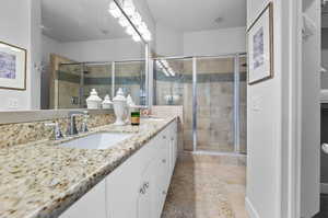 Bathroom with vanity, tile patterned floors, and walk in shower