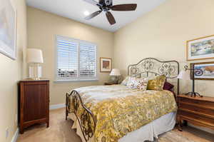 Bedroom with ceiling fan and light colored carpet