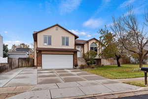 Split level home with a garage and a front lawn