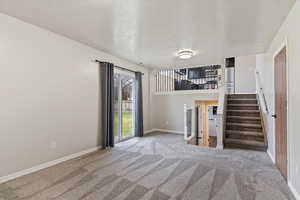 Interior space featuring light colored carpet and a textured ceiling