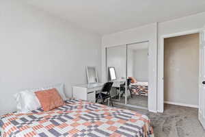 Carpeted bedroom with a closet