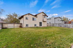 Rear view of property with a lawn