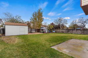 View of yard featuring a playground, a shed, and a patio area