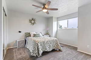 Bedroom featuring a closet, carpet, a textured ceiling, and ceiling fan