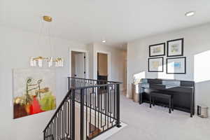 Loft featuring beautiful chandelier over modern sleek railing