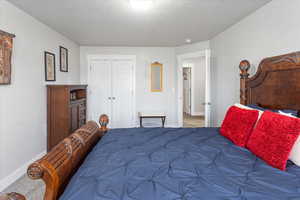 Bedroom featuring dark carpet and a closet