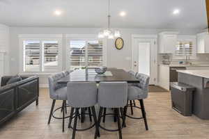 Dining area with light hardwood / wood-style flooring, sink, and a chandelier