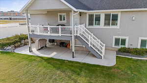 Rear view of house with a yard and a patio