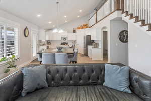 Living room featuring light hardwood / wood-style flooring, lofted ceiling, and sink