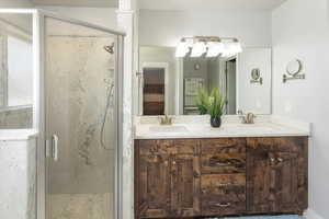 Bathroom with vanity and a shower with door