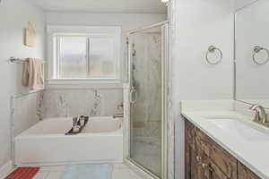 Bathroom featuring tile patterned flooring, vanity, and independent shower and bath