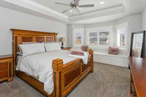 Bedroom with carpet floors, a tray ceiling, ceiling fan, and ornamental molding