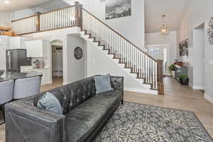 Living room with a towering ceiling and light hardwood / wood-style floors