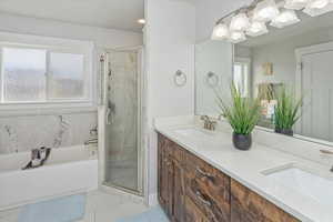 Bathroom featuring tile patterned flooring, vanity, and independent shower and bath