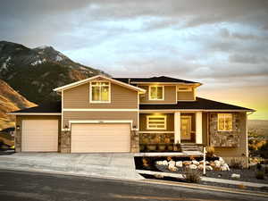 View of front of house with a mountain view and a garage