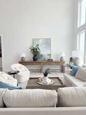 Living area featuring a high ceiling, baseboards, and wood finished floors