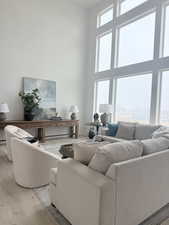 Living room with a towering ceiling and light wood-style flooring