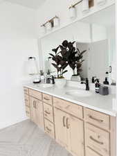 Full bath featuring double vanity, a sink, and baseboards