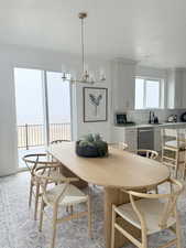 Dining area featuring a textured ceiling, a water view, and an inviting chandelier