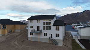 Back of house featuring a mountain view and a balcony