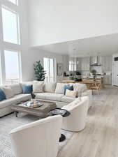 Living area with light wood-type flooring and a high ceiling