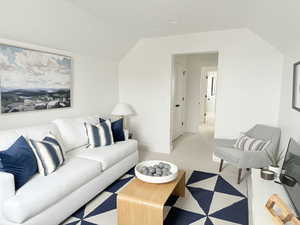 Living area featuring lofted ceiling, light carpet, and baseboards