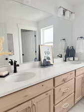 Full bath featuring double vanity and a sink