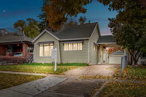 View of cute Cottage style home at twilight