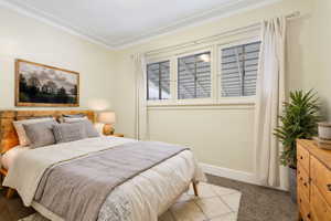 Carpeted bedroom featuring ornamental molding  (Staged by AI)