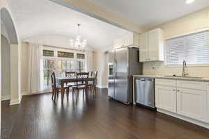 Kitchen featuring white cabinetry, sink, dark wood-type flooring, and appliances with stainless steel finishes