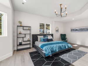 Bedroom featuring wood-type flooring, multiple windows, and a chandelier