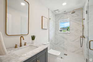 Bathroom featuring vanity, toilet, walk in shower, and tile patterned flooring