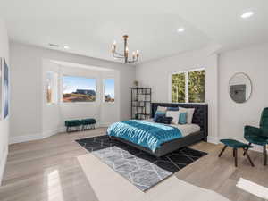 Bedroom featuring light hardwood / wood-style flooring and a chandelier