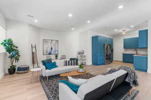 Living room featuring light wood-type flooring and sink