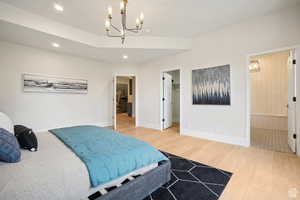 Bedroom with a chandelier, hardwood / wood-style floors, a walk in closet, and a closet