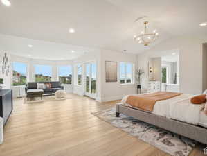 Bedroom featuring a chandelier, light hardwood / wood-style floors, and vaulted ceiling