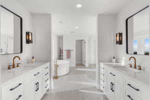 Bathroom with a tub to relax in, vanity, and tile patterned flooring