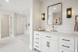 Bathroom with vanity and a shower with door