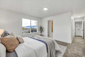 Bedroom featuring ensuite bath and light carpet