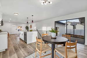 Dining room with an inviting chandelier and light hardwood / wood-style flooring