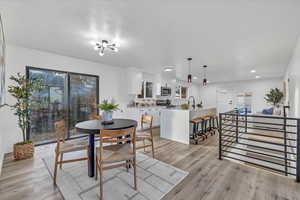 Dining area featuring a chandelier, light wood-type flooring, and sink