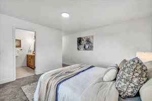 Bedroom with light colored carpet and ensuite bath