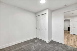 Unfurnished bedroom with hardwood / wood-style flooring and a closet