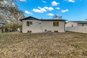 Rear view of house with a yard