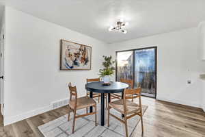 Dining area featuring light hardwood / wood-style floors and a notable chandelier