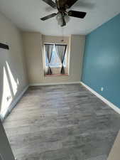 Empty room featuring hardwood / wood-style flooring and ceiling fan