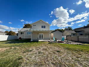 Back of house with a yard, a patio area, french doors, and a fire pit